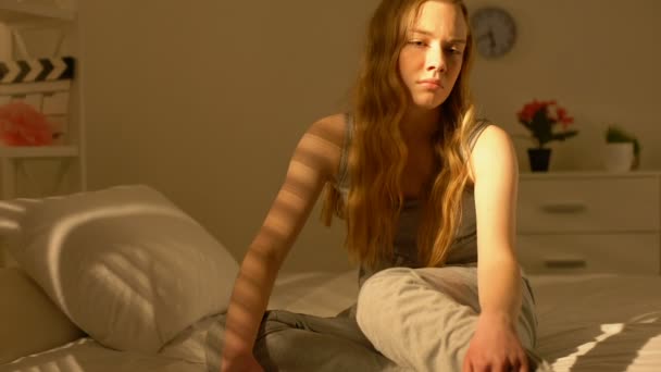 Депрессивный подросток лежит на кровати, страдает от одиночества, плохого настроения, неуверенности в себе — стоковое видео