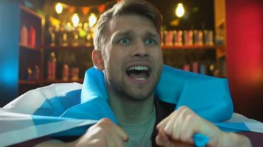 Üzgün erkek fan barda Arjantin bayrağı tutan, takım kaybetme hakkında hayal kırıklığına uğradım