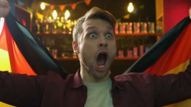 Alman bayrağını sallayan son derece sevindim erkek taraftar, milli takım zaferine seviniyor