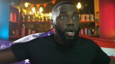 Barda ABD bayrağını sallayan Afro-Amerikan spor taraftarı, milli takım golüne seviniyor