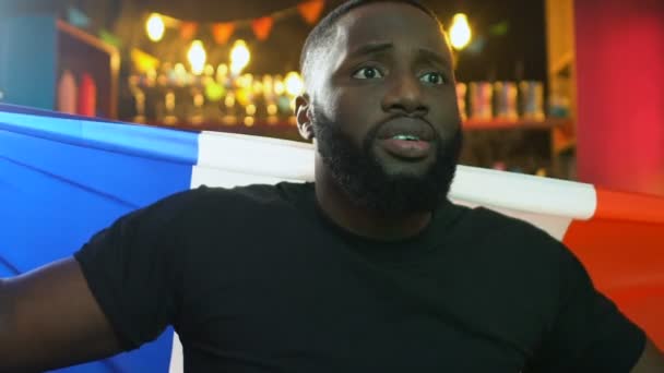 Афро-американський вентилятор з французьким прапором дивляться матч в паб, засмучений про поразку — стокове відео