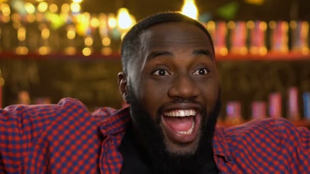 快乐的非洲裔美国体育迷在酒吧观看比赛，庆祝球队胜利 — 图库视频影像
