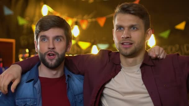 Group of happy caucasian friends watching sport game in bar, celebrating victory — Stock Video