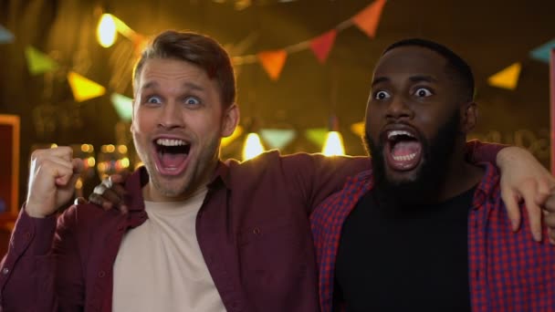 Sorrindo multiétnicos fãs do sexo masculino regozijando a vitória da equipe nacional de esportes no bar — Vídeo de Stock