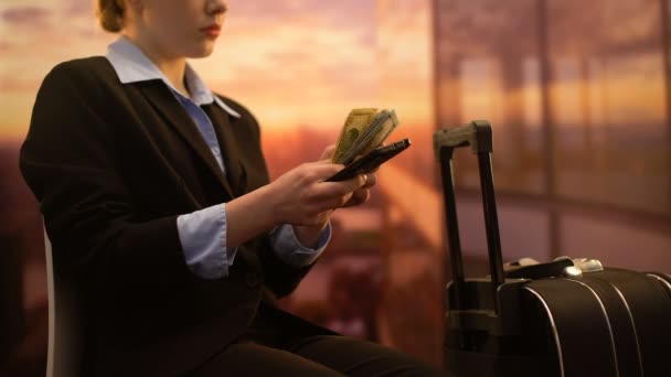 Mujer de negocios sentada en el aeropuerto y utilizando la aplicación de teléfono celular para contar el dinero para el viaje — Vídeos de Stock