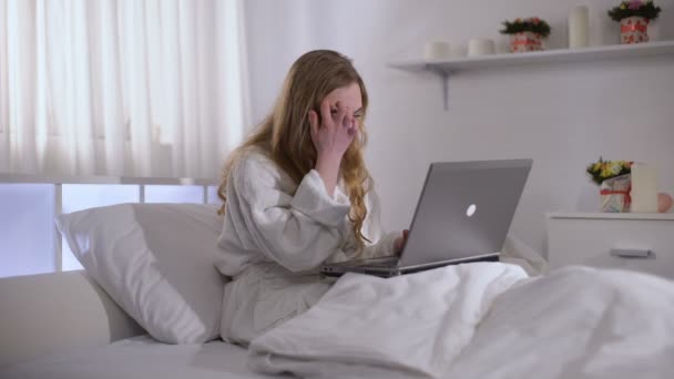 Ragazza preoccupata che lavora su computer portatile a letto fino al mattino, scadenza in freelance — Video Stock