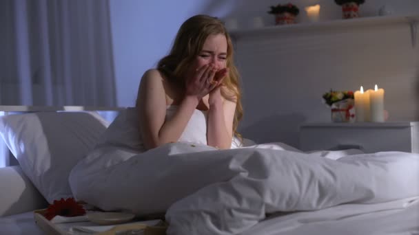 Женщина ест пончики и плачет в постели, борясь со стрессом из-за чрезмерной еды — стоковое видео