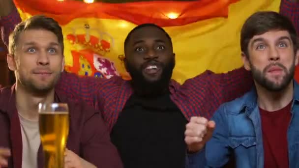 Sports fans with Spanish flag cheering for national team, watching game in pub — Stock Video