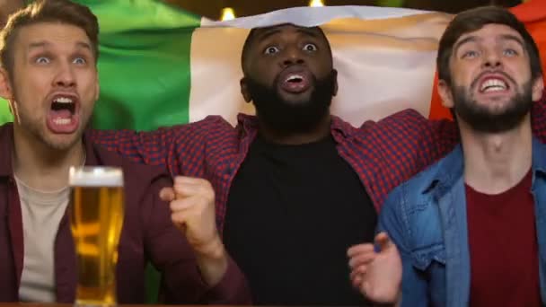 Спортивні вболівальники з італійським прапором аплодують для національної збірної, спостерігаючи за грою в пабі — стокове відео