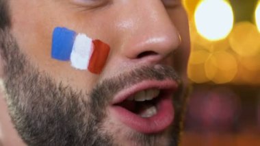 Yanak üzerinde boyalı Fransız bayrağı ile Man fan duygusal milli takım için tezahürat