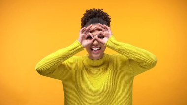 Oynak kız öğrenci gösteren dürbün jest açık göz, eğleniyor