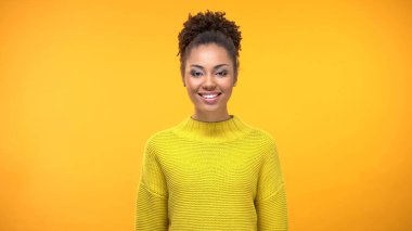 Gülen iyi görünümlü kadın görünümlü kamera parlak arka plan, gençlik pozitifliği