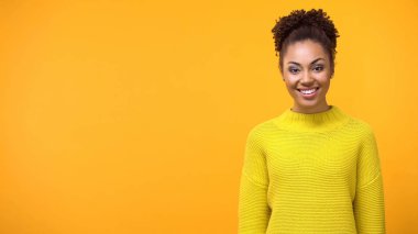 Parlak arka planda duran pozitif genç kadın, güzel kadın genç