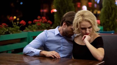 Kötü ruh halinde genç bir kadın, erkek arkadaşıyla konuşmaya gönülsüz, üzgün ve kıskanç.