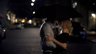 Şemsiye tutan, onun sevgili sarılma ve tarihi akşam zevk adam