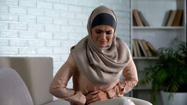 Genç Müslüman kadın mide ağrısı çekiyor, mide iltihabı geçiriyor.