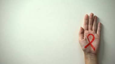 Kırmızı kurdele işaretiyle el AIDS ve HIV bilinci ve önleme kampanya