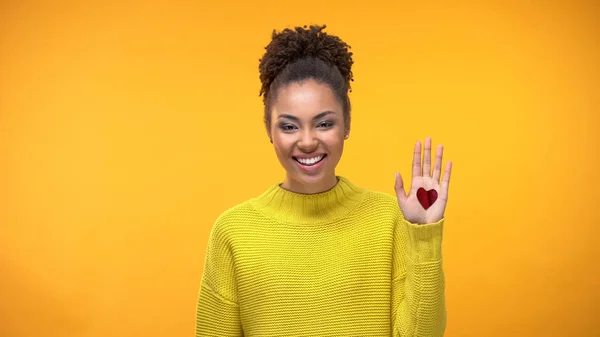 快乐的黑人女人表现出开放的手掌与心的标志 真诚的爱 — 图库照片