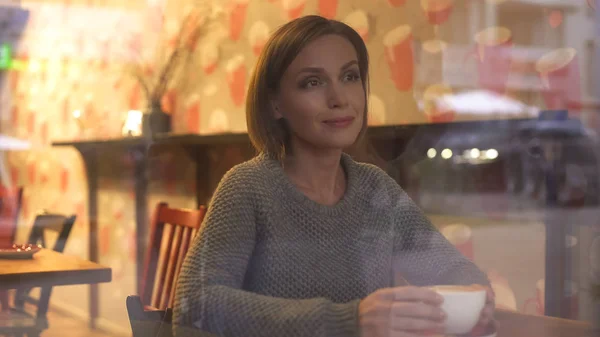 Задумчивая Женщина Смотрит Прохожих Через Окно Своей Любимой Кофейни — стоковое фото