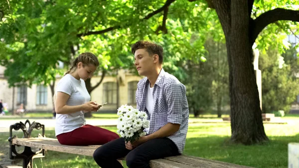 Schüchterner Teenager Mit Blumen Sitzt Neben Dame Surft Netz Telefon — Stockfoto