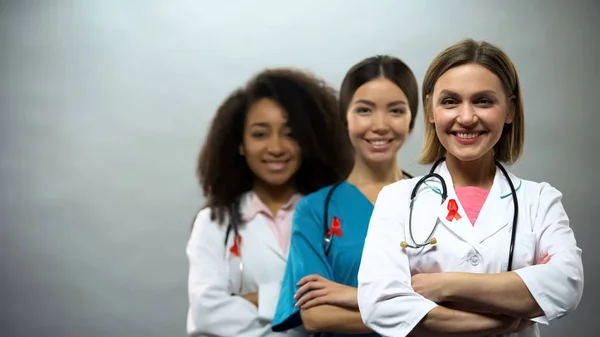 Lächelnde Multirassische Ärzte Mit Roten Bändern Internationales Aids Aufklärungsschild — Stockfoto