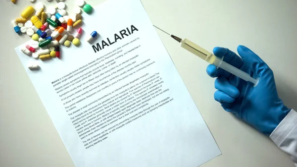 Malaria Word Typed Paper Doctor Hand Syringe Pills Tablets Table — Stock Photo, Image