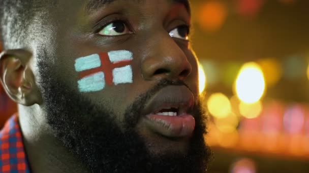 Fan de sport noir avec drapeau anglais sur la joue contrarié par la perte de l'équipe préférée — Video