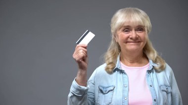 Memnun yaşlı Bayan banka müşteri gösteren kartı mali programı emekliler için