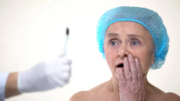 老年女士害怕手与柳叶刀 消极态度对手术治疗 — 图库照片
