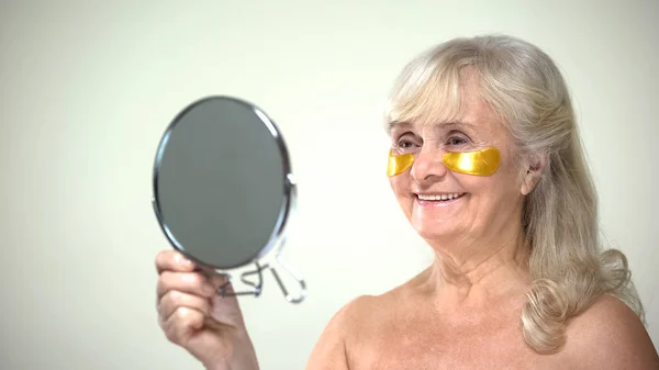 Smiling Female Applying Eye Patches Looking Mirror Aging Therapy — Stock Photo, Image