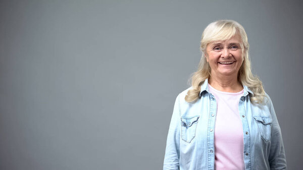 Old beautiful woman smiling enjoying life, place for advertisement, template