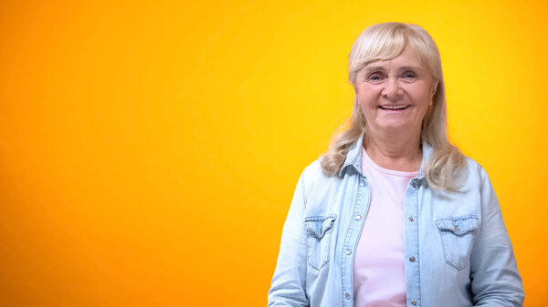 Old lady laughing on bright background, feeling healthy and financially secure