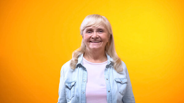 Friendly old lady smiling on camera, concept of satisfied customer, good service