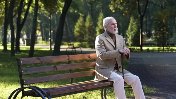 歩行棒の休息 公園に座って 暖かい天候を楽しむ年金受給者 — ストック写真