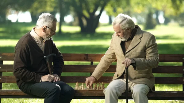 老朋友坐在公园的长椅上下棋 快乐的闲暇时间 — 图库照片