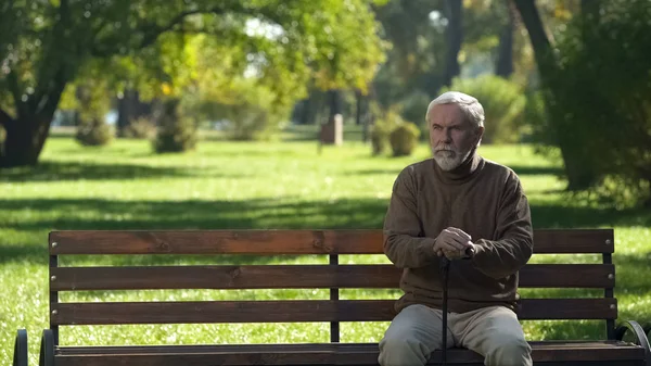 老人手杖坐在长凳上 在公园里散步后休息 — 图库照片