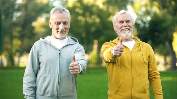 Zwei Lächelnde Ältere Männer Sportkleidung Zeigen Daumen Hoch Gesunder Lebensstil — Stockfoto