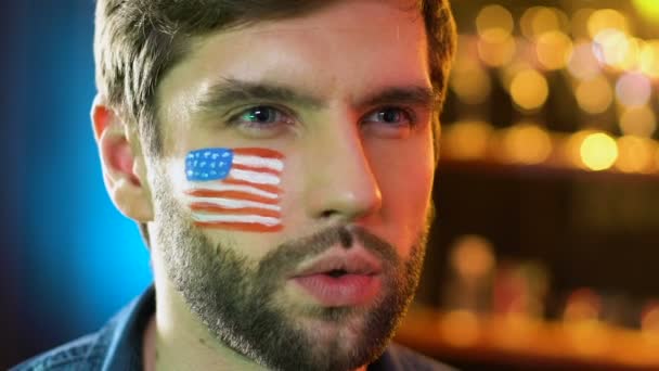 Αμερικανός οπαδός του ποδοσφαίρου με σημαία στο μάγουλο αγαλλίαση αγαπημένη ομάδα νίκη, πρωτάθλημα — Αρχείο Βίντεο