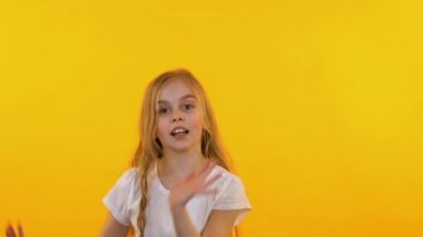 Neşeli kız dans komik dans izole sarı arka plan, yavaş hareket