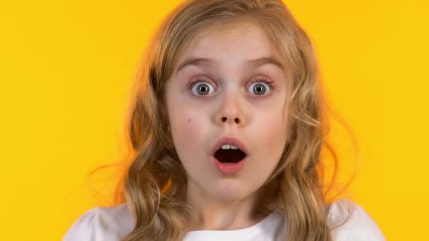 Klein schoolmeisje sluit ogen met handen, Kid is bang voor enge film, close-up — Stockvideo