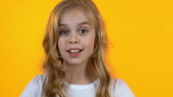 Vrolijk meisje winking toont OK teken, blij met goederen voor kinderen, close-up — Stockvideo