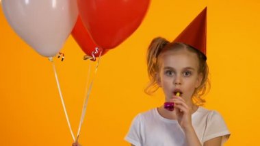 Parti üfleyici kullanarak balonlar ile Joyful b-day kız ve kamera, eğlenceli gülüyor