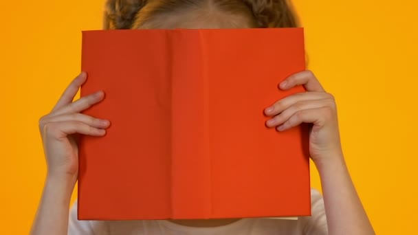 Pequeno garoto inteligente em óculos lendo enciclopédia chocado por fatos interessantes — Vídeo de Stock