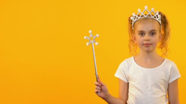 Hermosa princesa chica ondeando varita mágica y sonriendo a la cámara, infancia feliz — Vídeos de Stock