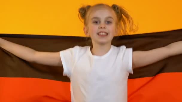 Радісний дитина вентилятор розмахуючи прапором Німеччини, підбадьорюючи для національної спортивної команди підтримки — стокове відео