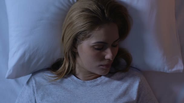 Mulher bonita dormindo na cama, relaxante à noite após longo dia, vista superior — Vídeo de Stock