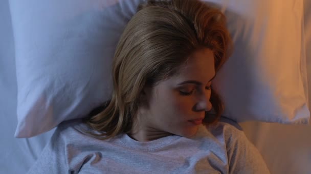 Hübsche Frau dehnt sich im bequemen Bett, Morgensonne vor dem Fenster — Stockvideo