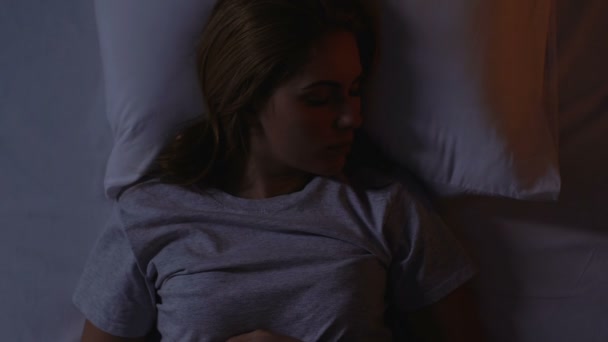 Frau wirft und dreht sich im Bett, kaum morgens wach, Schlaflosigkeit, Draufsicht — Stockvideo