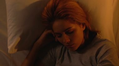 Rahat yatak ile yatakta uyuyan kadın, sabah güneş ışınları dışında