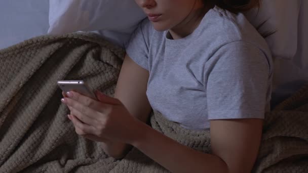 Mulher usando smartphone na cama, conversando em redes sociais, vício em gadgets — Vídeo de Stock